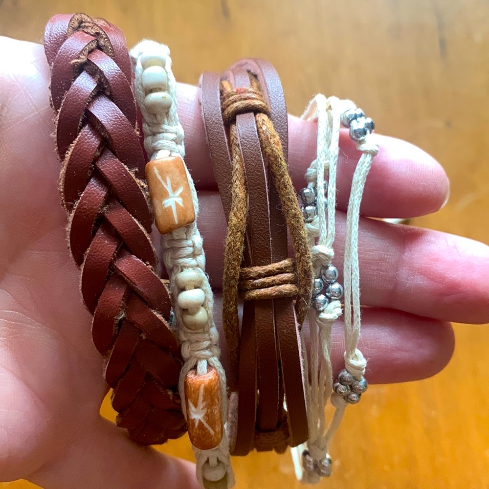 Four brown leather and cream bracelets